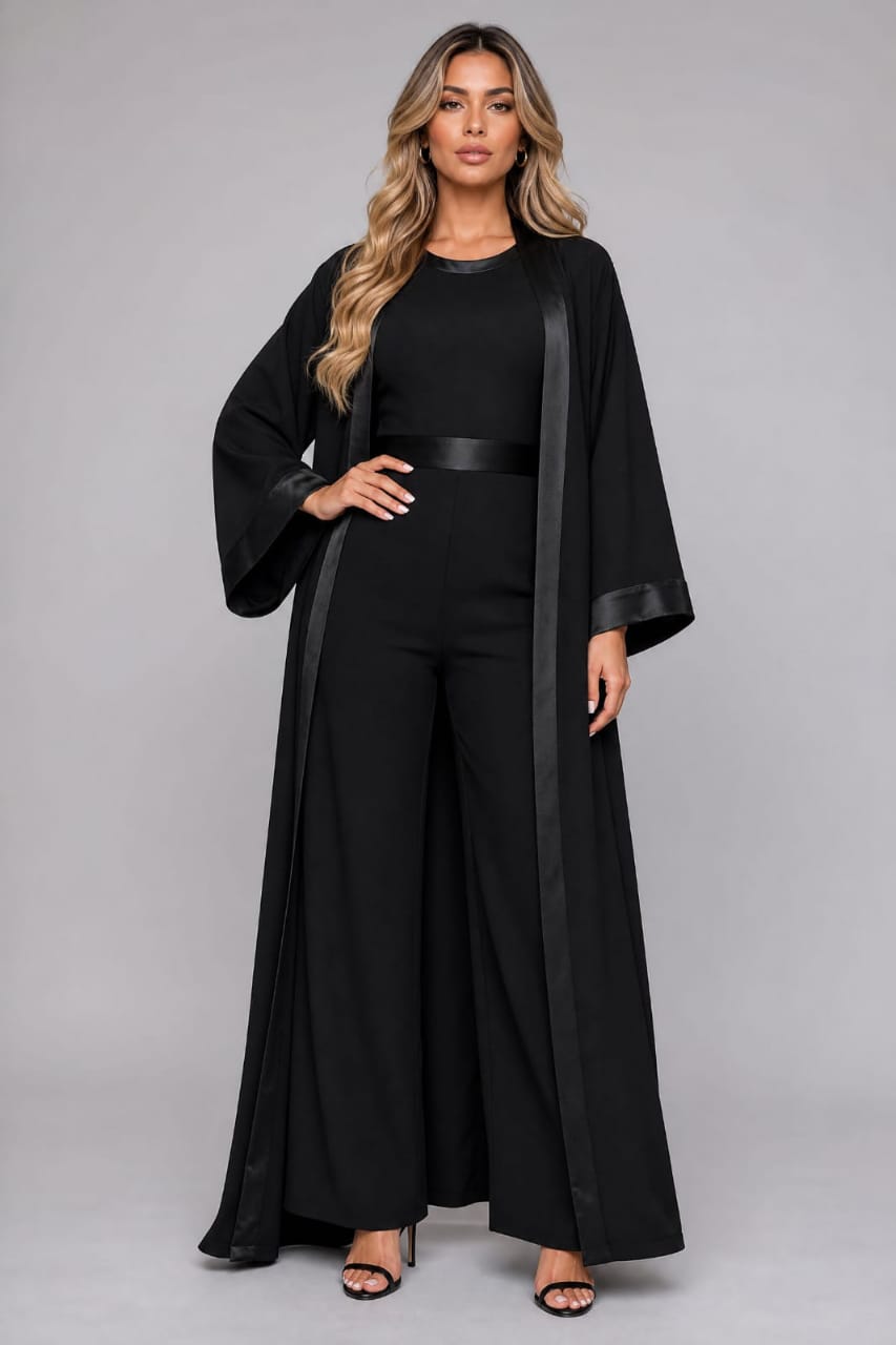 Model wearing a flowing black abaya with satin trim